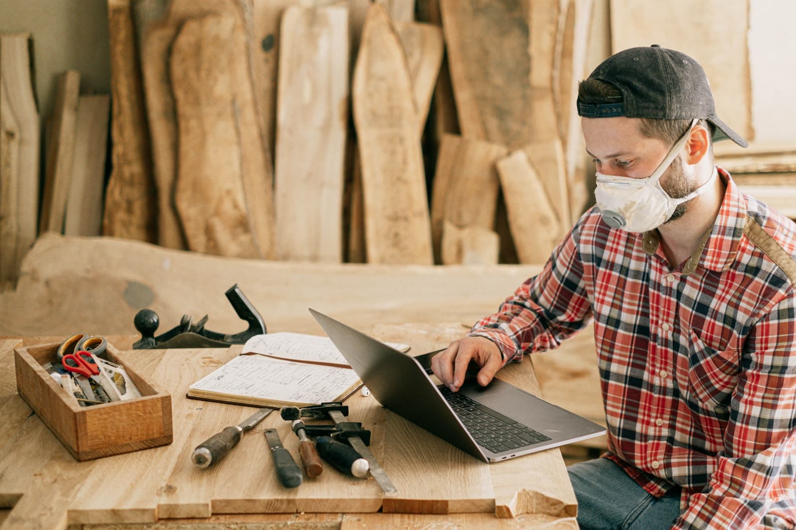 A contractor at his workbench following up on a bid from his laptop